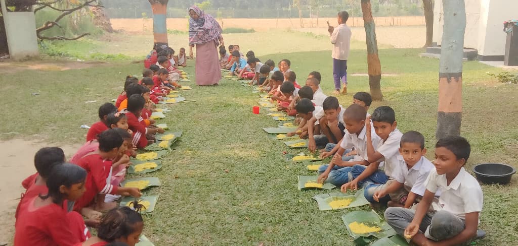 বিদ্যালয়ের মাঠে বসে কলাপাতায় খাবার খায় ওরা