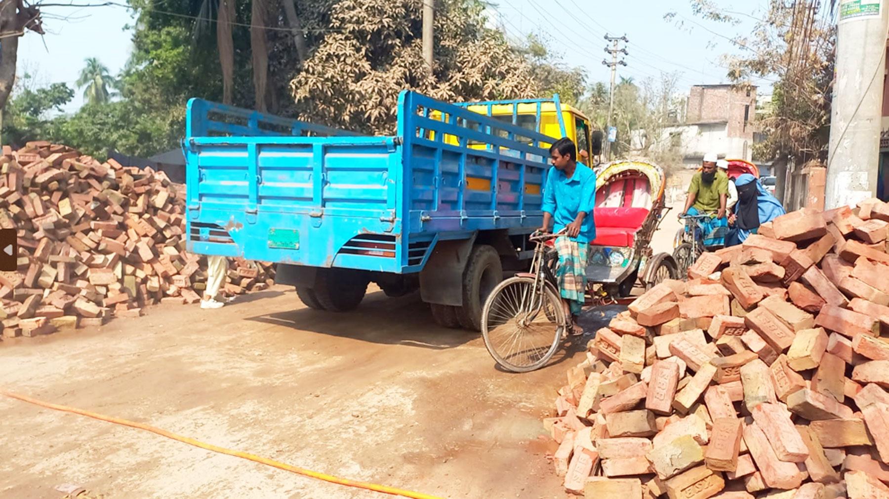 রাস্তার দুই পাশে নির্মাণসামগ্রী, ভোগান্তিতে জনসাধারণ