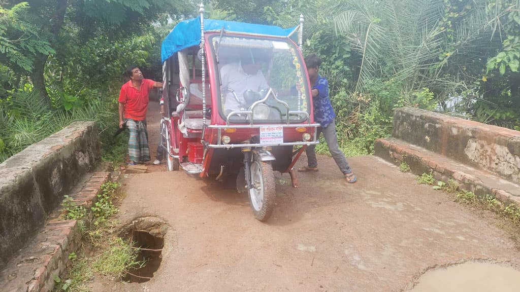 জীর্ণ সেতুতে ঠেলে গাড়ি পার