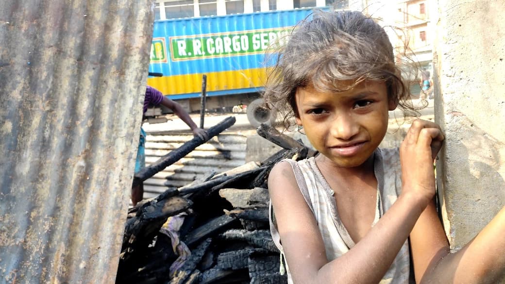 স্কুলে যাবে বলে পোড়া স্তূপে বই খুঁজছে শিশুটি