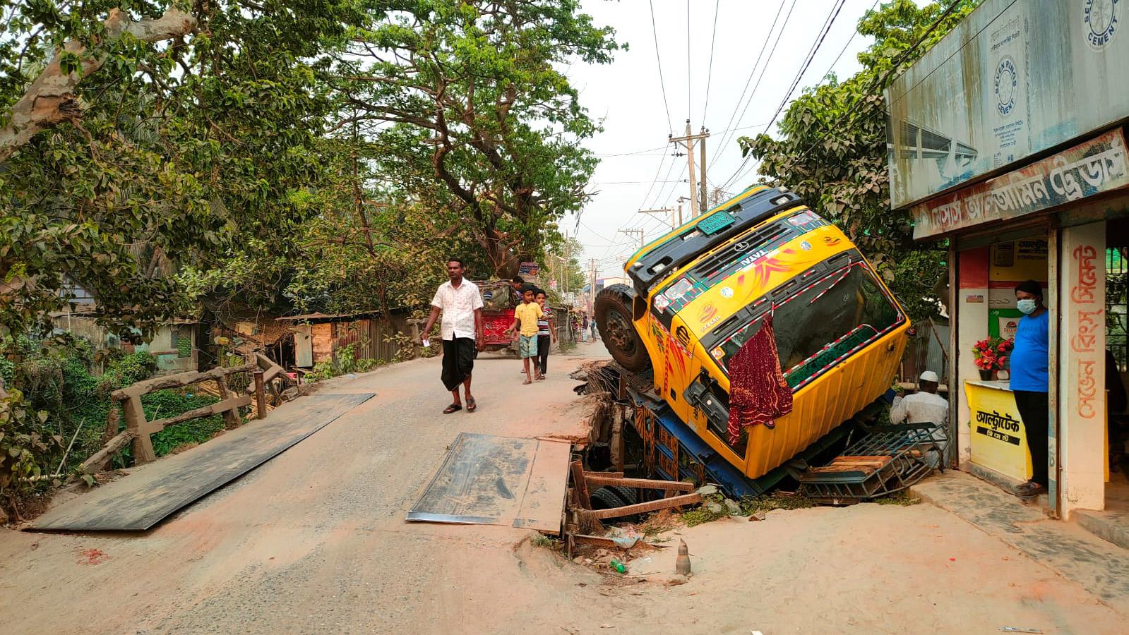 সেতুর একাংশ ভেঙে পণ্যবোঝাই ট্রাক খাদে