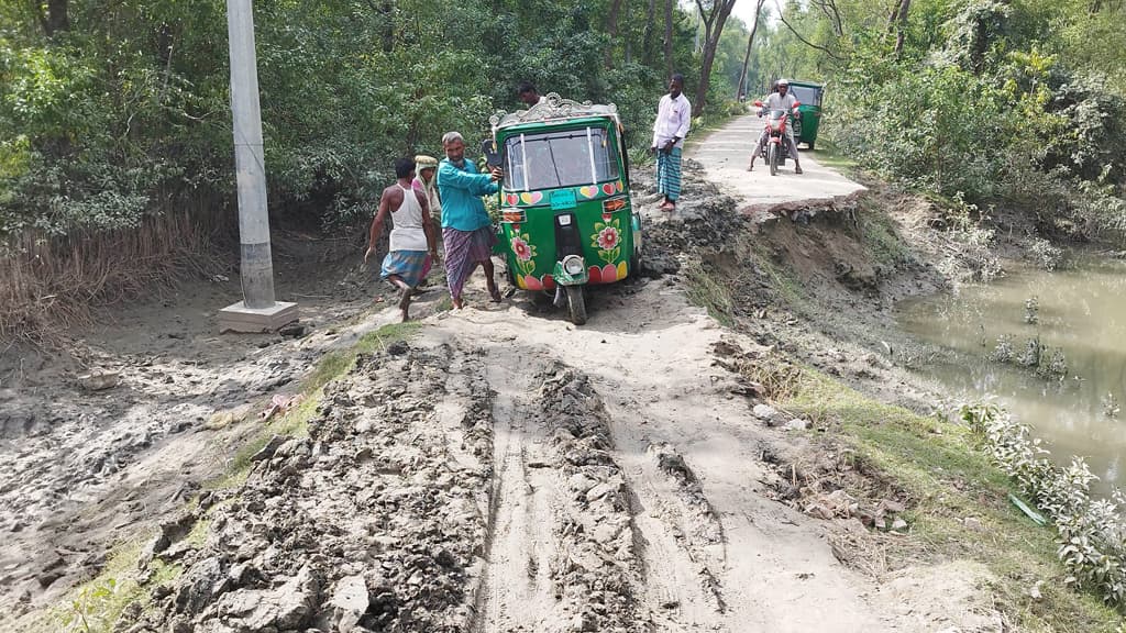 প্রধান সড়কে বড় গর্ত ঠেলে ঠেলে যান পার