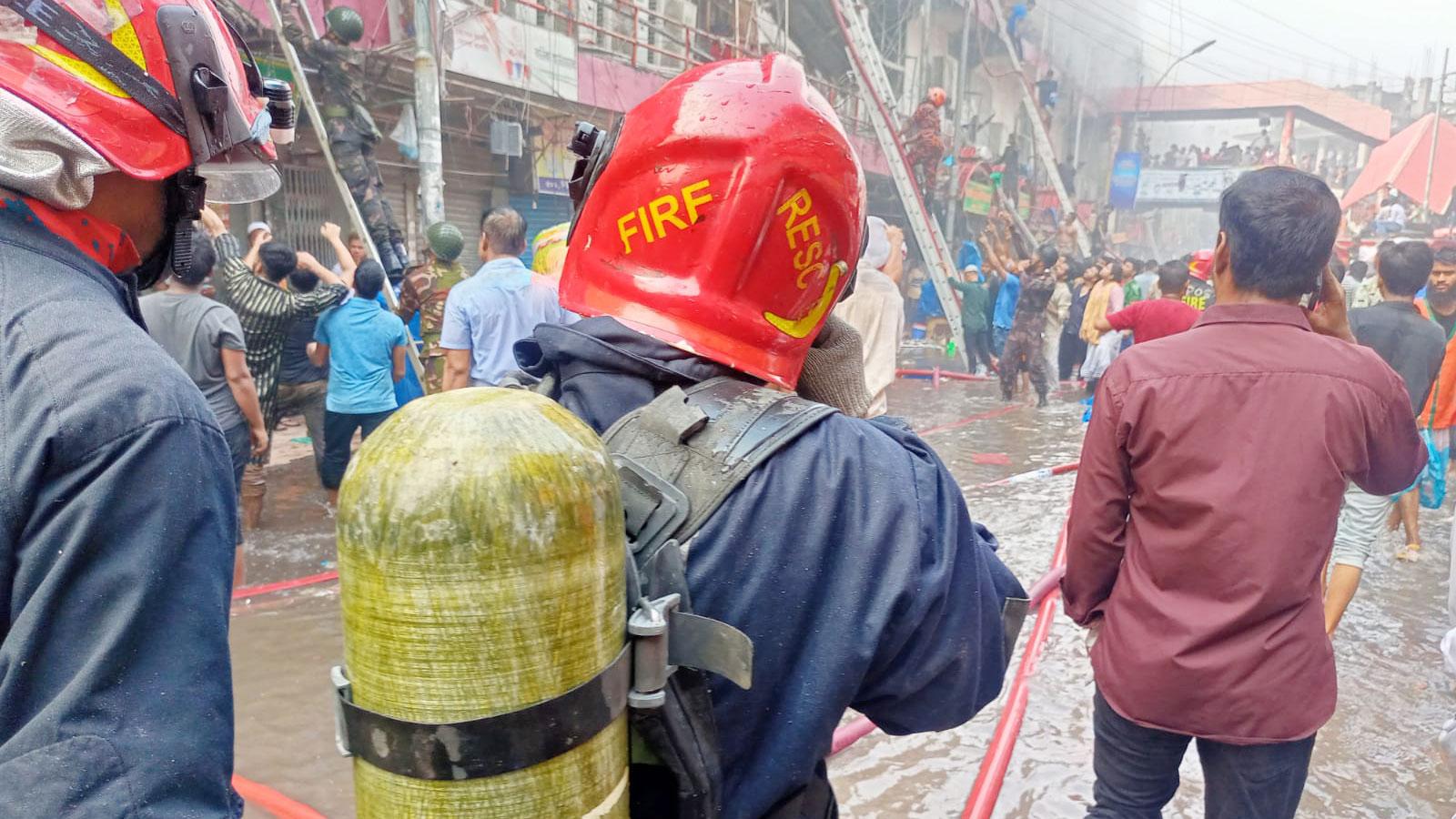 অক্সিজেন সিলিন্ডার নিয়ে কাজ করছেন ফায়ার ফাইটাররা