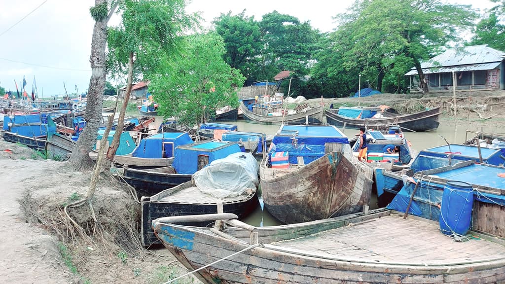 অবসর সময়ে ট্রলার ও জাল মেরামতে ব্যস্ত জেলেরা