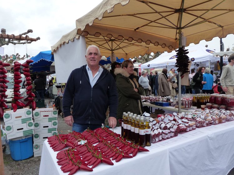 মরিচ চাষি মসিয়ঁ পিয়ের ডিহার্চ। নিজের উৎপাদিত মরিচ নিয়ে জায়া ও পুত্র নিয়ে উপস্থিত হয়েছেন উৎসবে। ছবি: লেখক।