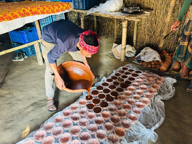 তরল গুড় ঢালা হচ্ছে পাত্রে। ছবি: আজকের পত্রিকা