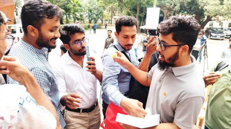 ডাকসু ভবনের সামনে আয়োজিত এক অনুষ্ঠানে মিষ্টি বিতরণ করেছেন বিপ্লবী ছাত্র পরিষদের নেতা–কর্মীরাও। ছবি: আজকের পত্রিকা