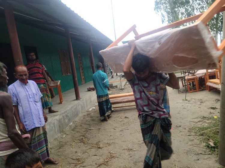 বিদ্যালয়ের জিনিসপত্র নিরাপদ স্থানে সরিয়ে নিচ্ছেন শ্রমিকেরা। ছবি: আজকের পত্রিকা