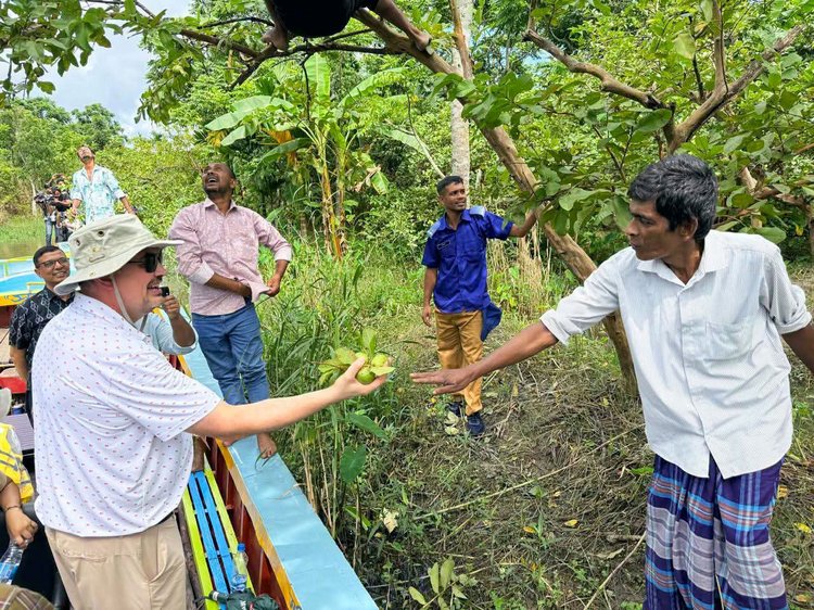 স্থানীয় এক চাষির হাত থেকে পেয়ারা নিচ্ছেন বাংলাদেশে নিযুক্ত মার্কিন রাষ্ট্রদূত ব্রেন্ট টি. ক্রিস্টেনসেন। ছবি: আজকের পত্রিকা
