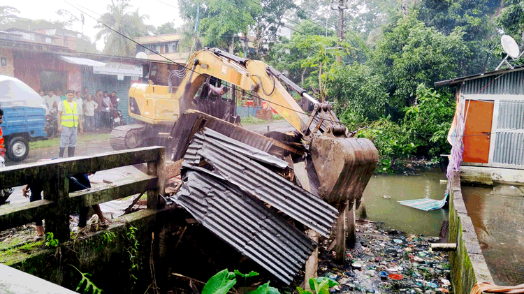 ঝালকাঠি পৌরসভার ১ নম্বর ওয়ার্ডের বিকনা এলাকায় খালের জমিতে গড়ে ওঠা অবৈধ স্থাপনা উচ্ছেদ এবং পরিষ্কার-পরিচ্ছন্নতা কার্যক্রম চলাকালে। ছবি: আজকের পত্রিকা