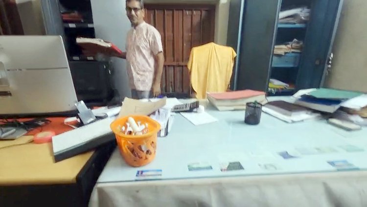 সাংবাদিকদের দেখে কাগজপত্র সরাচ্ছেন তহশিলদার আবুল বাশার। ছবি: আজকের পত্রিকা