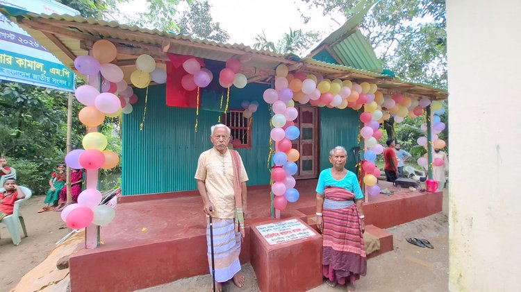 নেত্রকোনার দুর্গাপুর উপজেলার সদর ইউনিয়নের শ্যামনগর গ্রামের বাসিন্দা অশীতিপর বৃদ্ধা আদিবাসী পিকুলা হাজংকে নতুন ঘর উপহার দিয়েছেন ডেপুটি স্পিকার ব্যারিস্টার কায়সার কামাল। ছবি: আজকের পত্রিকা