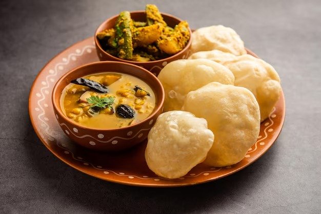 বেশি পরিমাণে লুচি খেলে দ্রুত রক্তচাপ বেড়ে যেতে পারে। এর জন্য হতে পারে বুকে জ্বালাপোড়া, পেট ভারী হয়ে অস্বস্তিকর অবস্থা। ছবি: ফ্রিপিক