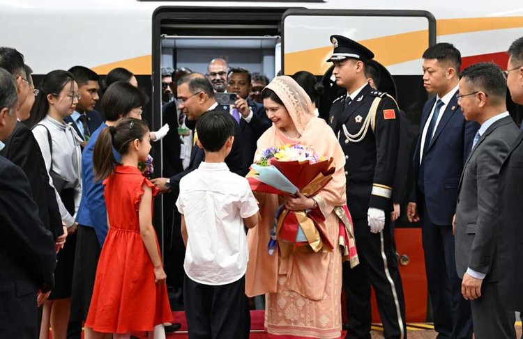 স্টেশনে শিশু-কিশোরেরা প্রধানমন্ত্রী ও তাঁর সহধর্মিণীর হাতে ফুলের তোড়া তুলে দেয়। ছবি: পিএমও