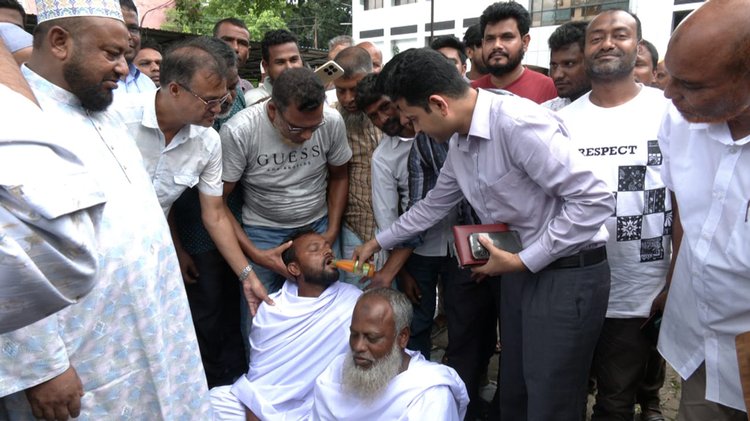 জেলা প্রশাসক মোহাম্মদ রুহুল আমিন অনশনকারী চাষিদের জুস খাওয়াচ্ছেন। ছবি: আজকের পত্রিকা