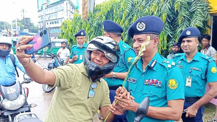 সিলেটে সড়কে হেলমেট পরিহিত মোটরসাইকেলের (বাইক) চালক-আরোহীদের ফুল দিয়ে শুভেচ্ছা। ছবি: আজকের পত্রিকা