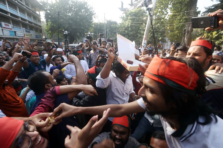 মানবতাবিরোধী অপরাধের মামলার রায় ঘোষণার পর টিএসসিতে মিষ্টি বিতরণ করা হয়। ছবি: আজকের পত্রিকা