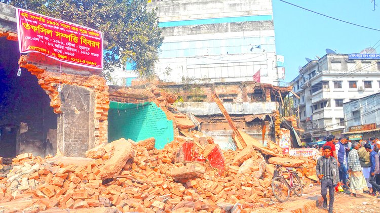 বগুড়ার সাতমাথায় জাসদ কার্যালয়ের জমির মালিকানা দাবি করে গতকাল সাইনবোর্ড টানানো হয়। ছবি: আজকের পত্রিকা