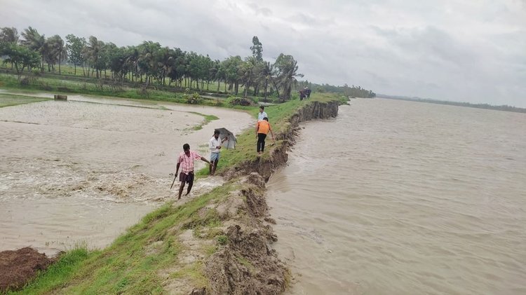 শঙ্খ নদীর পাড় ভেঙে লোকালয়ে পানি ঢুকছে। বাঁধ দিয়ে পানি ঠেকানোর চেষ্টা করছেন স্থানীয়রা। আজ বৃহস্পতিবার চট্টগ্রামের আনোয়ারা উপজেলার জুঁইদণ্ডী ইউনিয়নে। ছবি: আজকের পত্রিকা
