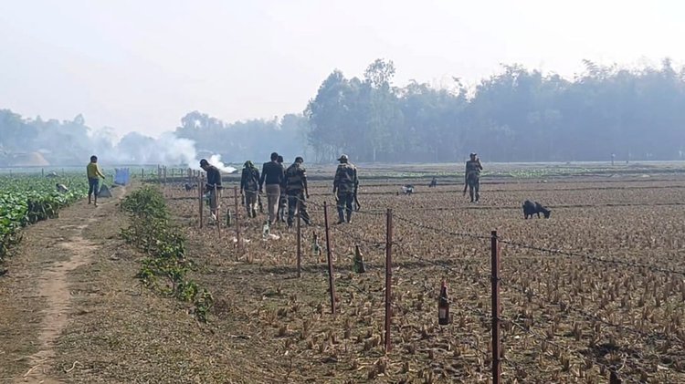 লালমনিরহাটের পাটগ্রাম উপজেলার দহগ্রাম সীমান্তের সরকার পাড়ার এলাকার বাংলাদেশ-ভারত প্রধান ৮ নম্বর পিলার এলাকায় নির্মিত কাঁটাতারের বেড়ায় খালি মদের বোতল ঝুলিয়ে দিচ্ছে বিএসএফ সদস্যরা। ছবি: আজকের পত্রিকা