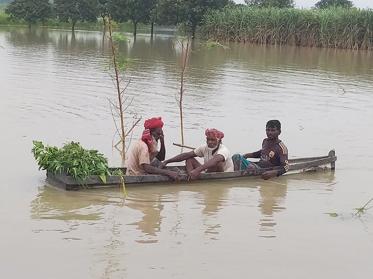 ডিঙি নৌকায় স্থানান্তরিত হচ্ছেন ভুক্তভোগী কয়েকজন। ছবি: আজকের পত্রিকা