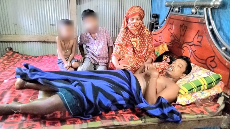 অসুস্থ জেলে বাবলুর পাশে তাঁর স্ত্রী ও দুই ছেলে। ছবি: আজকের পত্রিকা