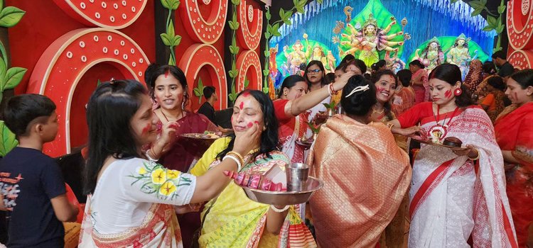 আজ দুপুরে পূজা-অর্চনা শেষে ভক্ত নারীরা দেবী দুর্গার চরণে সিঁদুর নিবেদন করে আনন্দে মেতে ওঠেন। ছবি: আজকের পত্রিকা