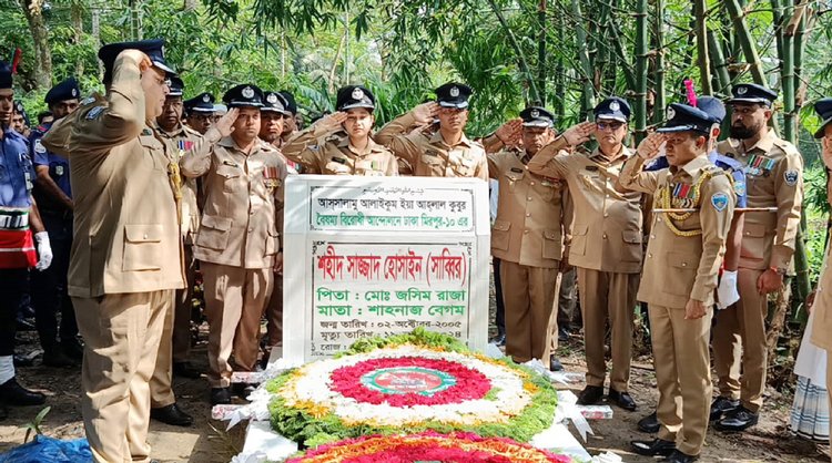 শহীদ হাফেজ সাজ্জাদ হোসেন সাব্বিরের কবরে পুষ্পস্তবক অর্পনের মাধ্যমে শ্রদ্ধা জানান পুলিশ সুপার মুহম্মদ আব্দুর রকিবসহ পুলিশ কর্মকর্তারা। ছবি: আজকের পত্রিকা