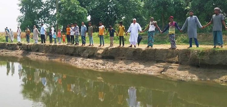 নদীভাঙন রোধের দাবিতে এলাকাবাসীর মানববন্ধন। ছবি: আজকের পত্রিকা
