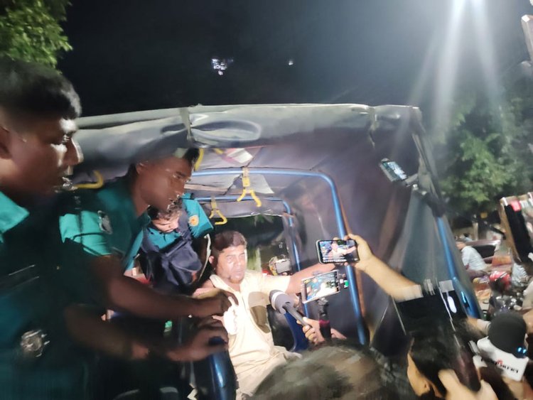 ধানমন্ডি ৩২ নম্বর থেকে আটক ব্যক্তিকে পুলিশের গাড়িতে তোলা হয়। ছবি: আজকের পত্রিকা