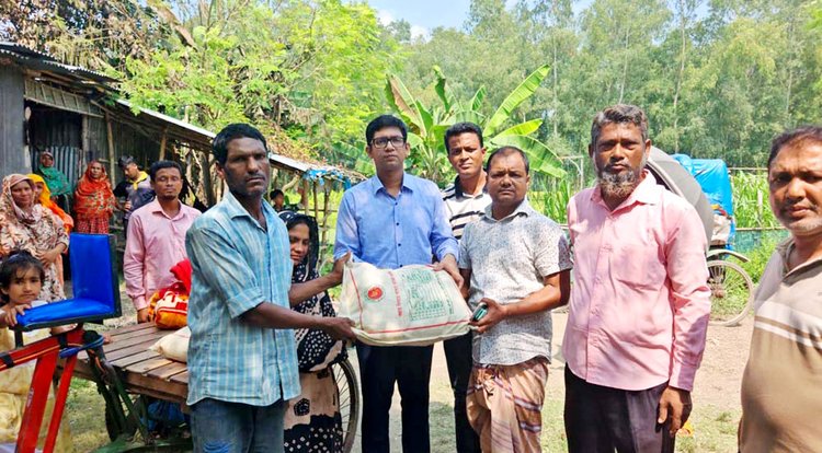 ক্ষতিগ্রস্ত পরিবারটিকে শুকনো খাবার ও নগদ অর্থ দেওয়া হয়। ছবি: আজকের পত্রিকা