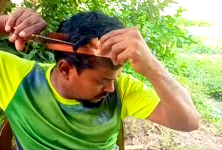 নিজের চুল নিজেই কাটছেন মুজাহিদুল। ছবি: সংগৃহীত