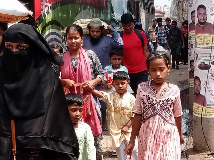 পরিবহন সংকটের কারণে অনেক যাত্রীকে কাঁধে কিংবা মাথায় মালপত্র বহন করতে দেখা গেছে। ধোলাইপাড় বাসস্ট্যান্ড এলাকায়। ছবি: আজকের পত্রিকা