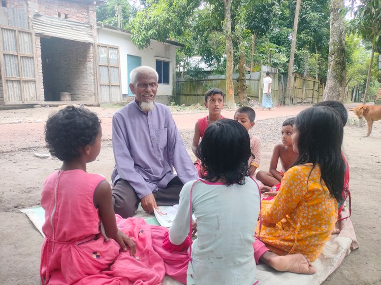 কোথাও রাস্তার ধারে, কোথাও গাছতলায় কিংবা বাঁধের ওপর বসে চলে লুৎফর রহমানের পাঠদান। ছবি: আজকের পত্রিকা