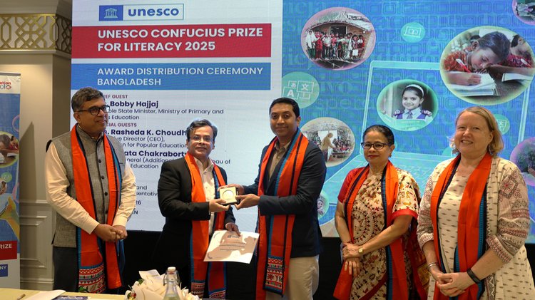 শিক্ষা প্রতিমন্ত্রীর হাত থেকে ইউনেসকো কনফুসিয়াস সাক্ষরতা পুরস্কার গ্রহণ করছেন মোহাম্মদ রেজোয়ান। আজ বুধবার বিকেলে হলিডে ইন ঢাকা সিটি সেন্টারে। ছবি: আজকের পত্রিকা।
