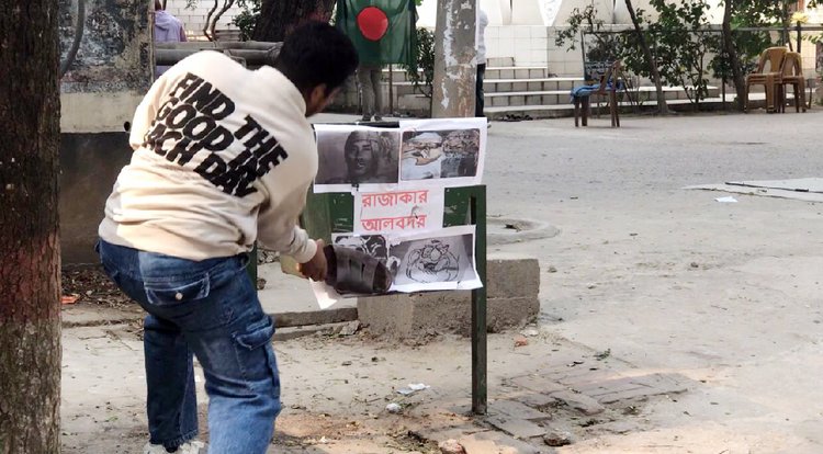 আজ মঙ্গলবার মহান বিজয় দিবসে রাজাকারদের ছবিতে জুতা নিক্ষেপ করেন জগন্নাথ বিশ্ববিদ্যালয়ের শিক্ষার্থীরা। ছবি: আজকের পত্রিকা