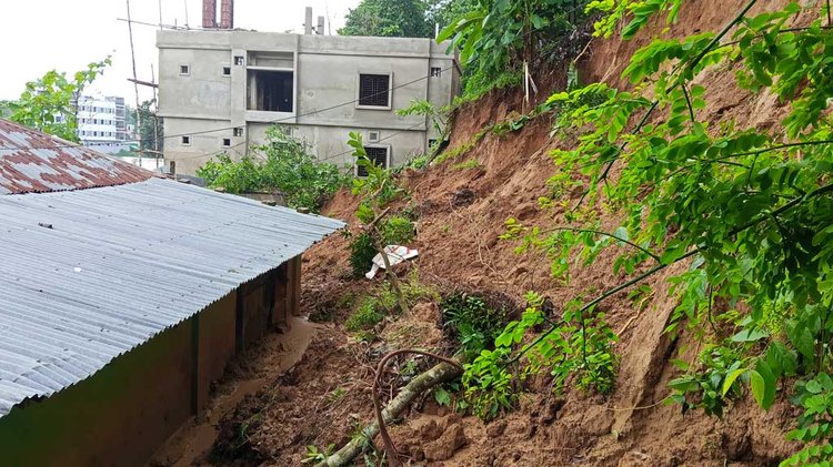 মানিকছড়ি উপজেলার মুসলিম পাড়া ও মাস্টার পাড়া এলাকায় শুক্রবার সকালে পাহাড় ভেঙে কয়েকটি বসত ঘরে মাটি ঢুকে পড়ে। ছবি: আজকের পত্রিকা