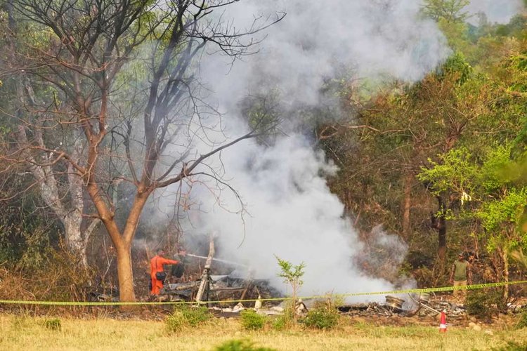 বুধবার জম্মুর উপকণ্ঠে আখনুরের কাছে একটি বিমান বিধ্বস্ত হওয়ার পর ধ্বংসাবশেষ থেকে ধোঁয়া নিয়ন্ত্রণে কাজ করেন দমকলকর্মীরা। ছবি: এএফপি