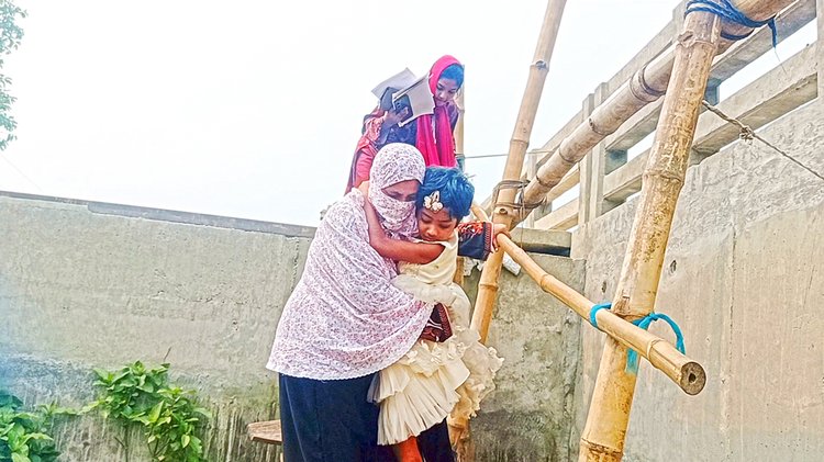 মই বেয়ে নতুন সেতু থেকে নামছে নারী ও শিশুরা। ছবি: আজকের পত্রিকা