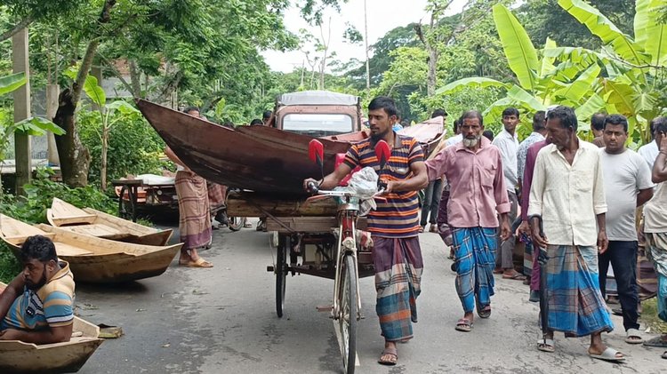 নৌকা কিনে ভ্যানে করে নিয়ে যাচ্ছেন ক্রেতা। ছবি আজকের পত্রিকা