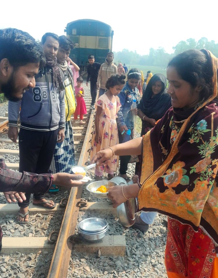 ট্রেনের ইঞ্জিন বিকল হওয়ায় ক্ষুধার্ত, তৃষ্ণার্ত মানুষের জন্য খাবার ও পানি নিয়ে এগিয়ে আসেন আশপাশের মানুষ। আজ রোববার বেলা ১১টার দিকে পাবনার সাঁথিয়া উপজেলার তাঁতীবন্দ এলাকায়। ছবি: সংগৃহীত