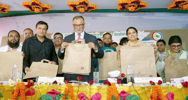 অনুষ্ঠানে পরিবেশবান্ধব পাটের ব্যাগ হাতে বাণিজ্য উপদেষ্টা ও পরিবেশ উপদেষ্টা। ছবি: আজকের পত্রিকা