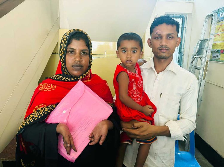 পায়ে লিখে জেলা প্রশাসকের কাছে চাকরির আবেদন করছেন প্রতিবন্ধী রাজিয়া। ঠাকুরগাঁও আইনজীবী সমিতিতে তোলা ছবিতে পাশে স্বামী আবু সুফিয়ান ও তাঁদের মেয়ে। ছবি: আজকের পত্রিকা