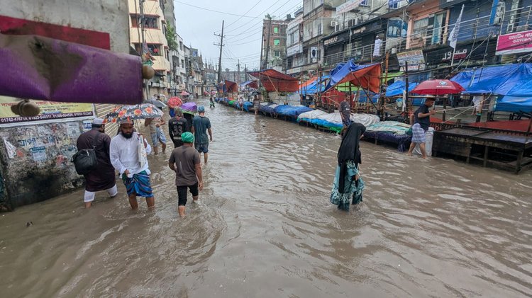 রাজধানীর যাত্রাবাড়ী এলাকায় ঢাকা-চট্টগ্রাম মহাসড়কে জলাবদ্ধতায় আটকে আছে গাড়ি, পানি মাড়িয়ে গন্তব্যে যাচ্ছে মানুষ। ছবি: মেহেদী হাসান