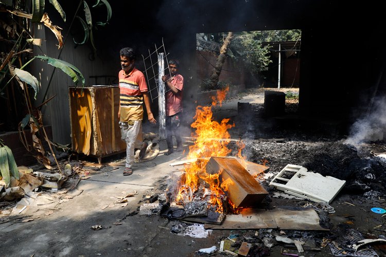 শেখ হাসিনার বাসভবন সুধা সদনে অগ্নিসংযোগের পর লুটপাট করে নানা শ্রেণি-পেশার মানুষ। ছবি: আজকের পত্রিকা