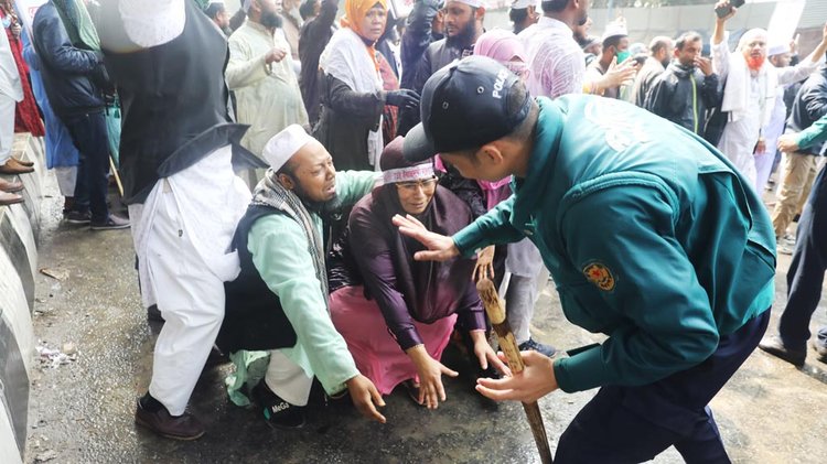 পুলিশের পায়ে পড়ে লাঠিপেটা না করতে অনুরোধ জানান দুই মাদ্রাসাশিক্ষক। ছবি: জাহিদুল ইসলাম