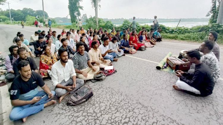 আজ সকাল ১০টা থেকে বেলা ১১টা পর্যন্ত বিশ্ববিদ্যালয়ের অস্থায়ী একাডেমিক ভবন-৩-এর সামনে মহাসড়কে প্রতীকী ক্লাস করে শিক্ষার্থীরা। ছবি: আজকের পত্রিকা