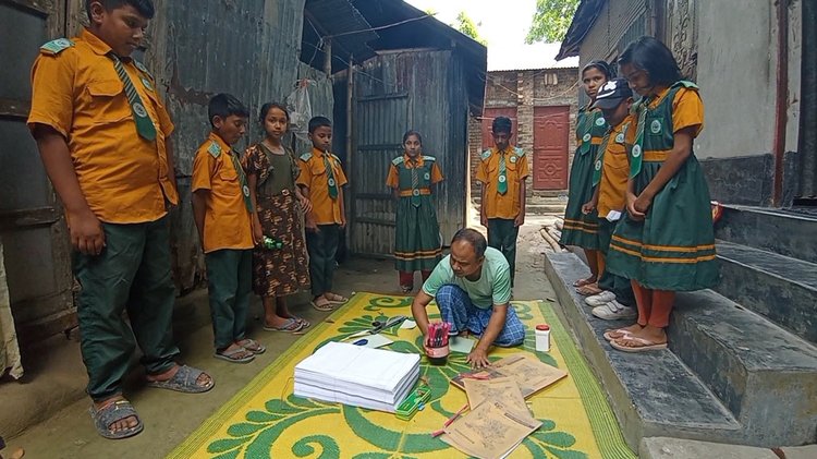 শরিফুল ইসলামের কলম ও খাতা তৈরি দেখছে শিশুরা। ছবি: আজকের পত্রিকা
