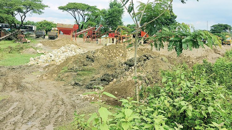 সিলেটে বিভিন্ন ক্রাশার মিলে রাখা ‘পাথর’ বালু ও মাটি দিয়ে লুকিয়ে রাখা হয়। ছবি: আজকের পত্রিকা