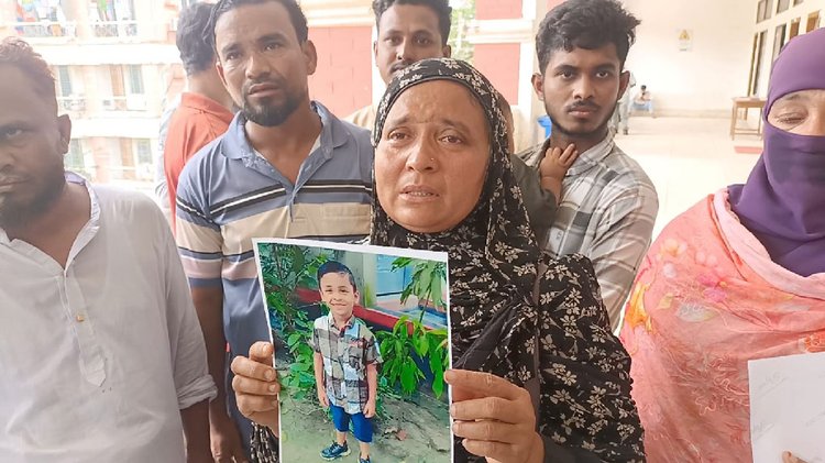 নিহত শিশু সায়মনের ছবি হাতে তার মা খোরশেদা আক্তার। ছবি: আজকের পত্রিকা